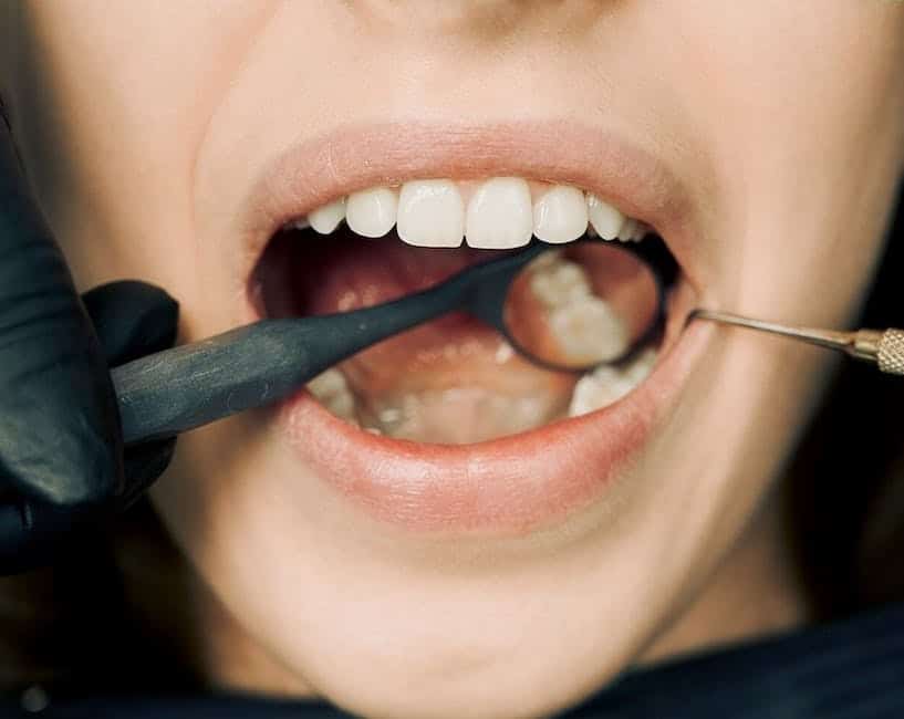 A close-up image of a healthy tooth being extracted from a gum.